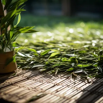 Fresh tea leaves drying on a bamboo mat - Image 1