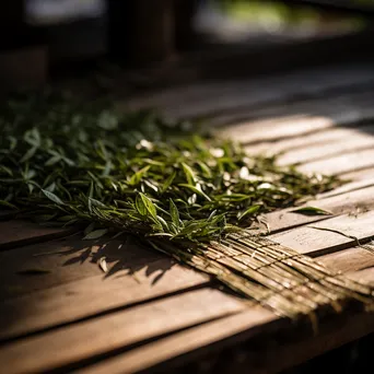 Fresh tea leaves drying on a bamboo mat - Image 4