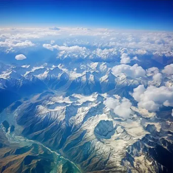 Majestic snow-capped mountains and green valleys seen from airplane window in aerial shot - Image 3