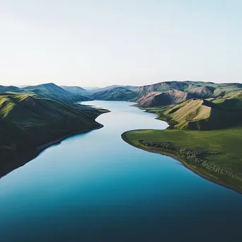 Aerial view of a tranquil blue lake surrounded by green hills. - Image 4