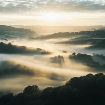 Misty valley landscape at dawn with sunlight breaking through fog - Image 3