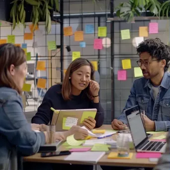 Team brainstorming session with sticky notes and laptops promoting collaboration and communication - Image 1