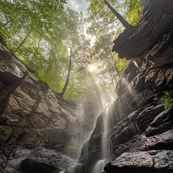 Cascading waterfall beside a steep mountain rock wall. - Image 3