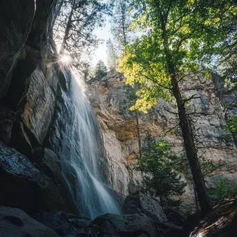 Cascading waterfall beside a steep mountain rock wall. - Image 4