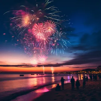 Fireworks lighting up a beach with people silhouetted watching the New Year