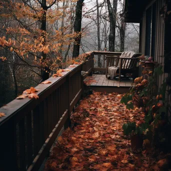 Wooden deck covered in autumn leaves with a sweater draped over the railing - Image 4