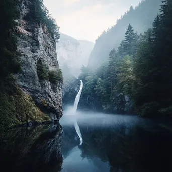 Waterfall cascading into a misty river with evening reflections - Image 4