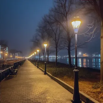 Calm riverside promenade with gentle streetlights overlooking city views at night - Image 4