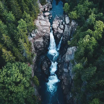 Aerial view of a cascading mountain waterfall and forest - Image 2