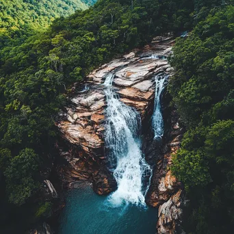 Aerial view of a cascading mountain waterfall and forest - Image 3