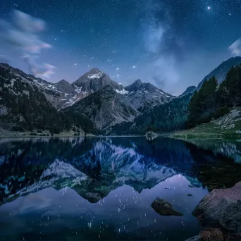 Moonlit mountain lake with reflection of stars - Image 1