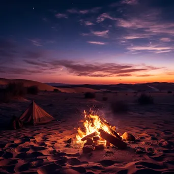 Campfire glowing against sand dunes at twilight - Image 2