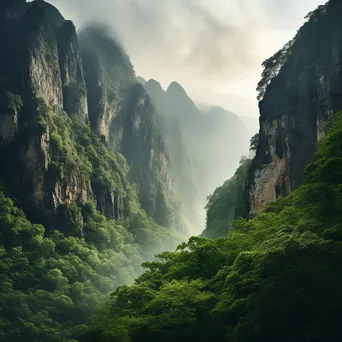 Sheer mountain cliff face surrounded by morning mist and greenery. - Image 2