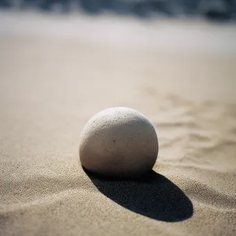 Smooth stone placed in soft sand - Image 3