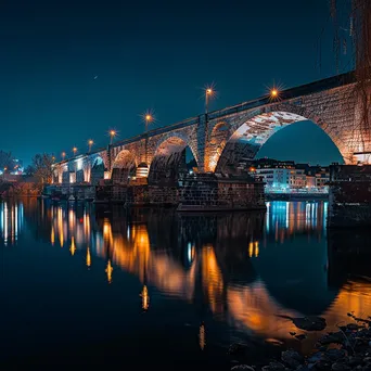 Long exposure photo of a historic bridge reflected in water at night - Image 4