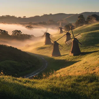 Row of vintage windmills on hillside at dawn - Image 4